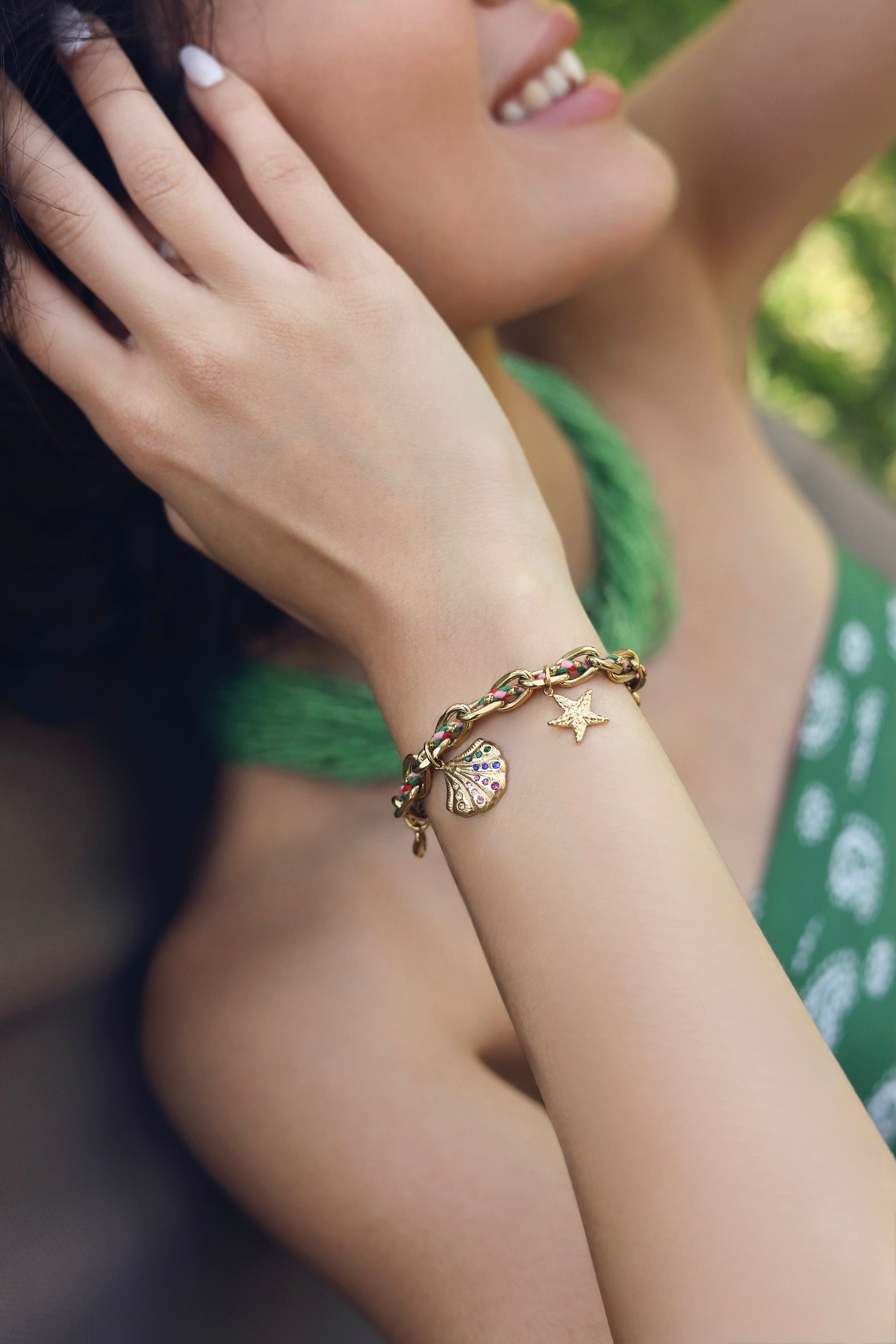 Bracelet à maille dorée Diandra sublimé par un cordon coloré entrelacé dans la chaîne, orné de pendentifs cauri, étoile de mer et coquillage sertis de zircons multicolores - Bijou porté