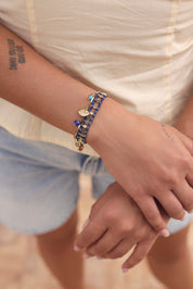 Bracelet doré Emery orné d’une étoile en sodalite, d’une main, d’un œil serti de zircon, d’une étoile polaire et de pendentifs en pierres bleues et en émail - Bijou porté