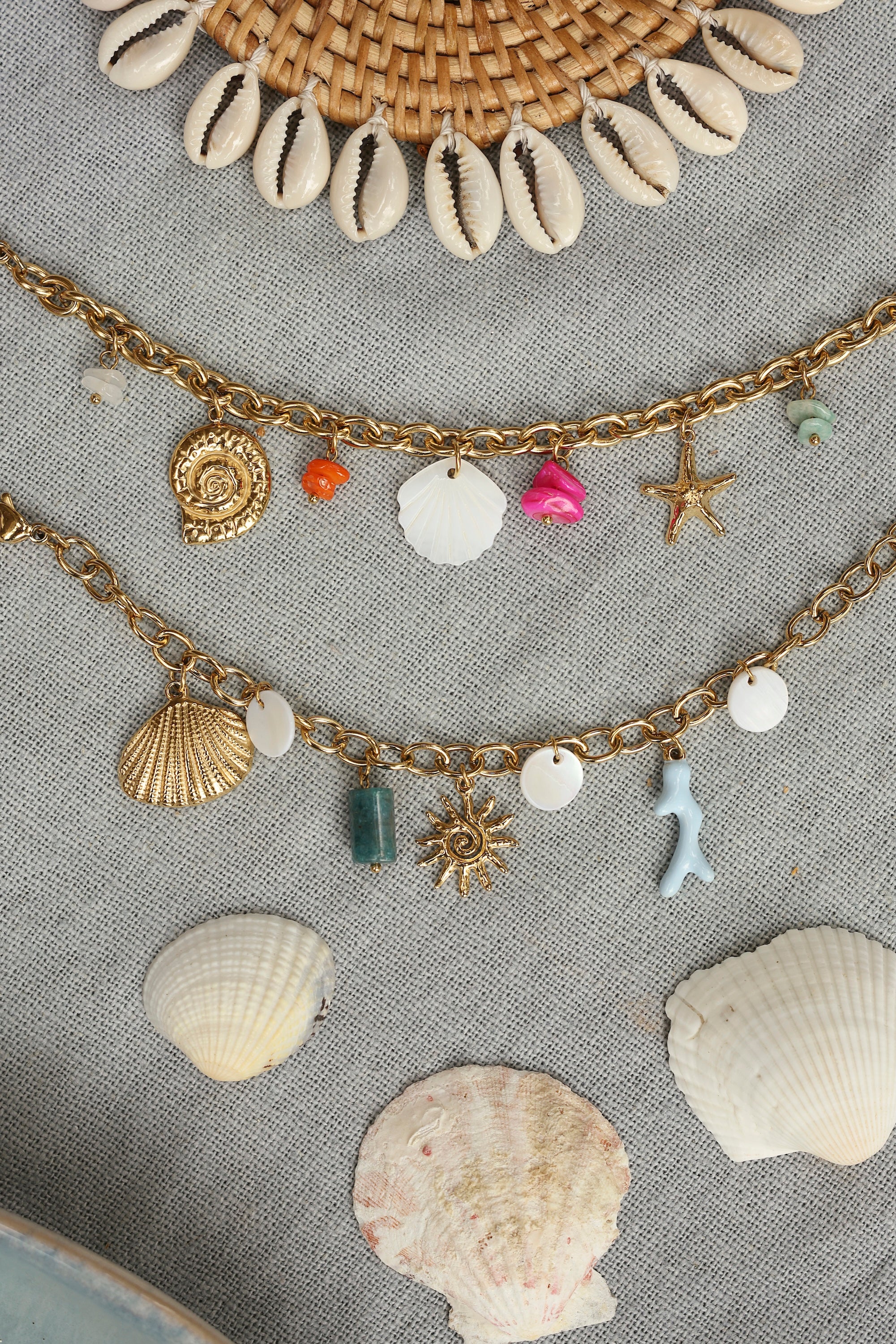 Bracelet doré Larysa pendentifs coquillage en nacre, coquillage doré, étoile de mer et pierres colorées - Bijou photographié dans un décor estival