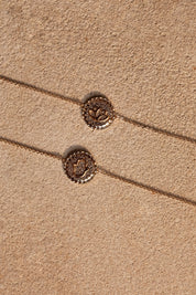 Bracelet doré mantra lotus gravé "Là où je suis, je fleuris" - Bijou photographié sur pierre beige
