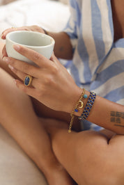 Bracelet doré Orlina orné d’une étoile en apatite, d’une lune, d'un soleil, d’une étoile polaire et de pendentifs en pierres naturelles et en émail - Bijou porté