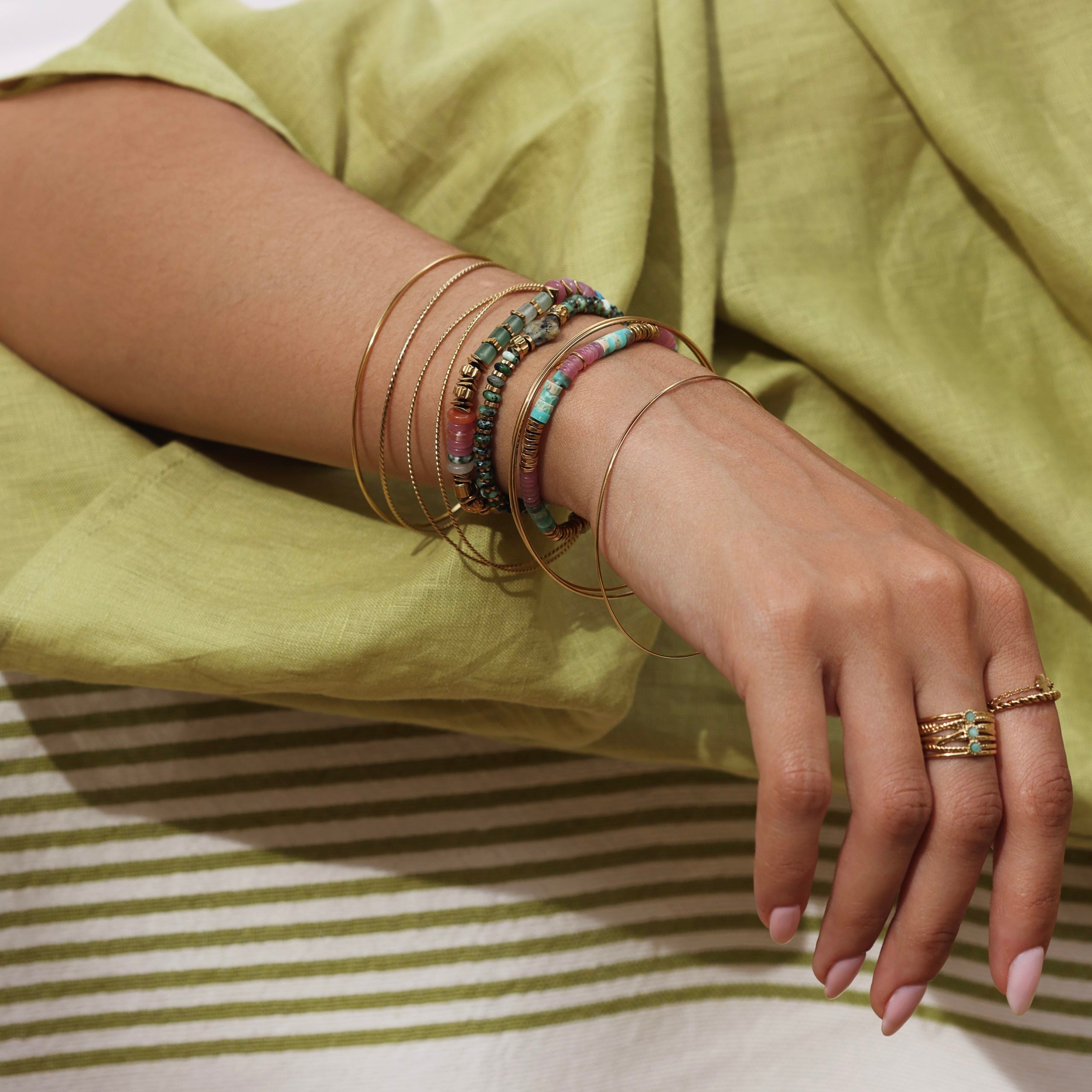 Bracelets semainier en acier inoxydable doré composés de 3 joncs torsadés, 3 joncs lisses et 1 jonc finement travaillé - Bijou porté
