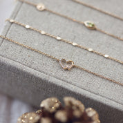  Bracelet doré Taylor cœur zircons - Bijou photographié sur présentoir en lin gris