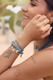 Bracelet doré Yarina bandana bleu avec pendentifs étoile de mer et coquillages - Bijou porté
