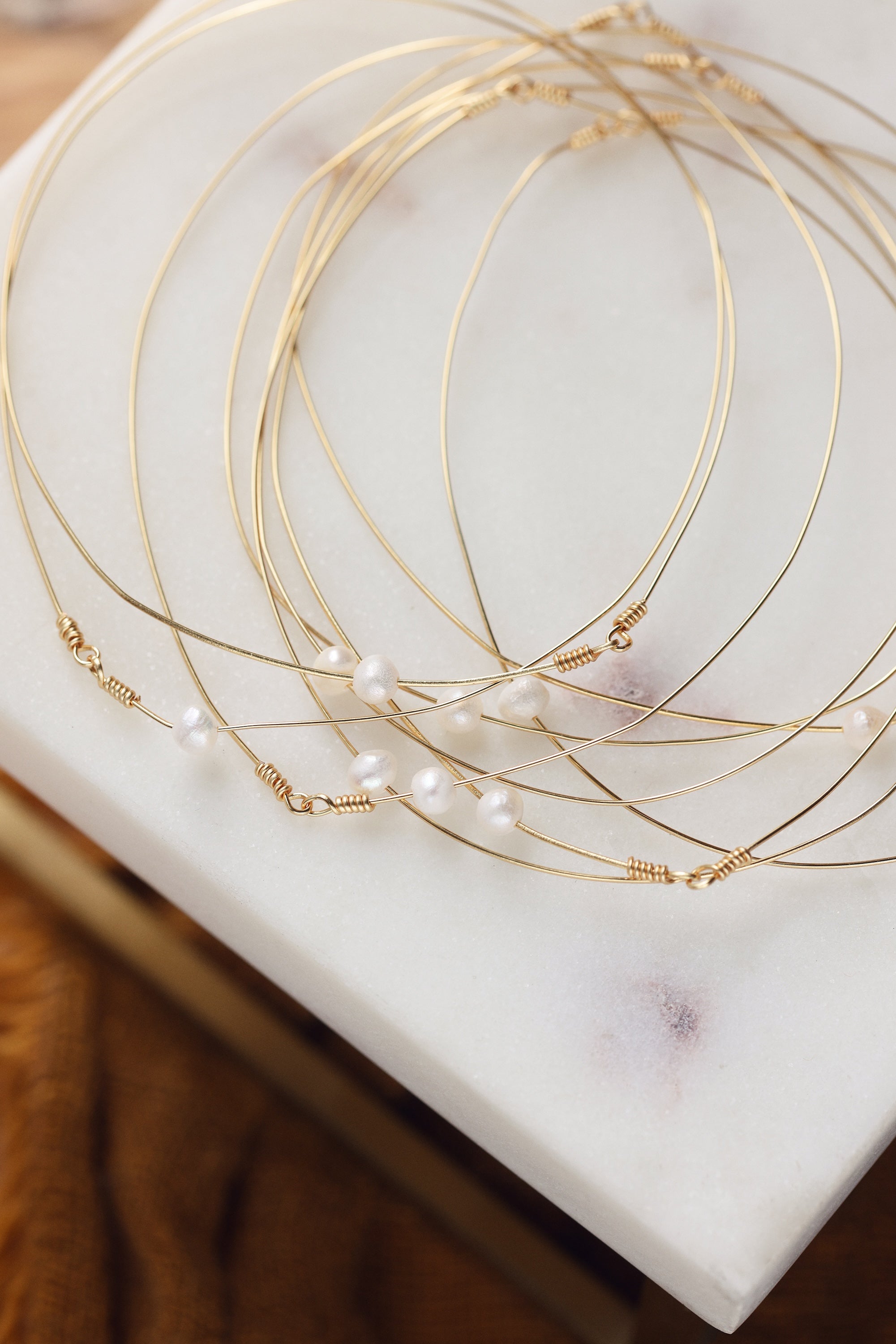 Bracelets semainiers Ali avec perles en nacres - Bijoux photographiés sur présentoir en marbre
