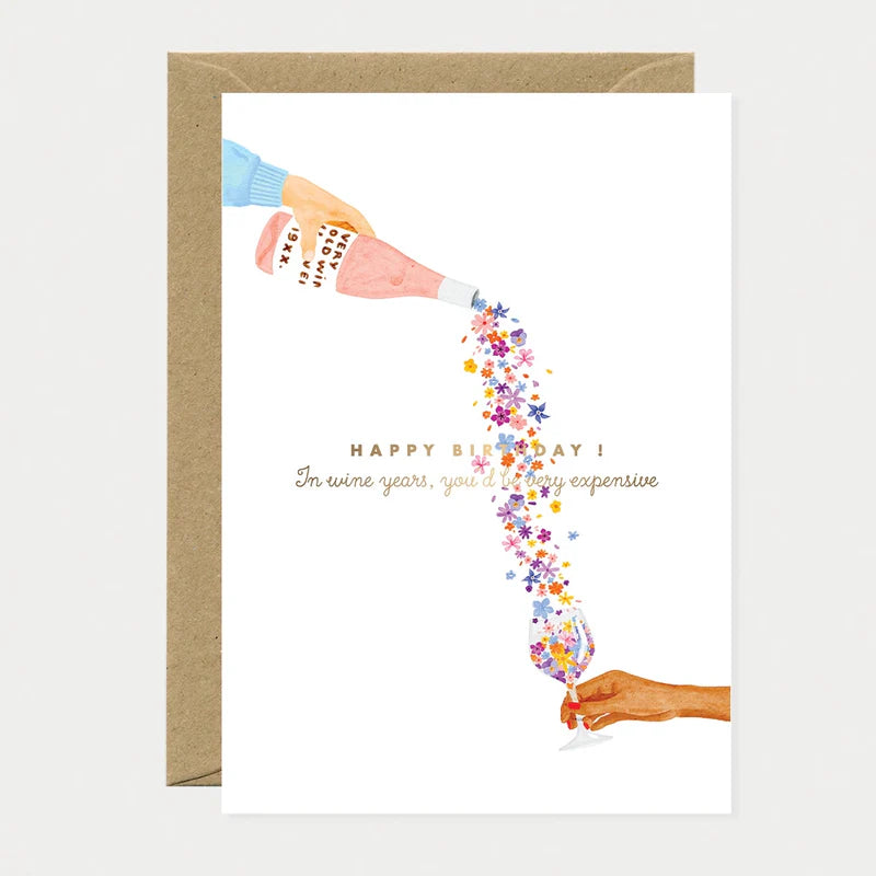 Carte d'anniversaire en papier naturel blanc avec une bouteille de vin qui verse des fleurs dans un verre à vin - Papeterie