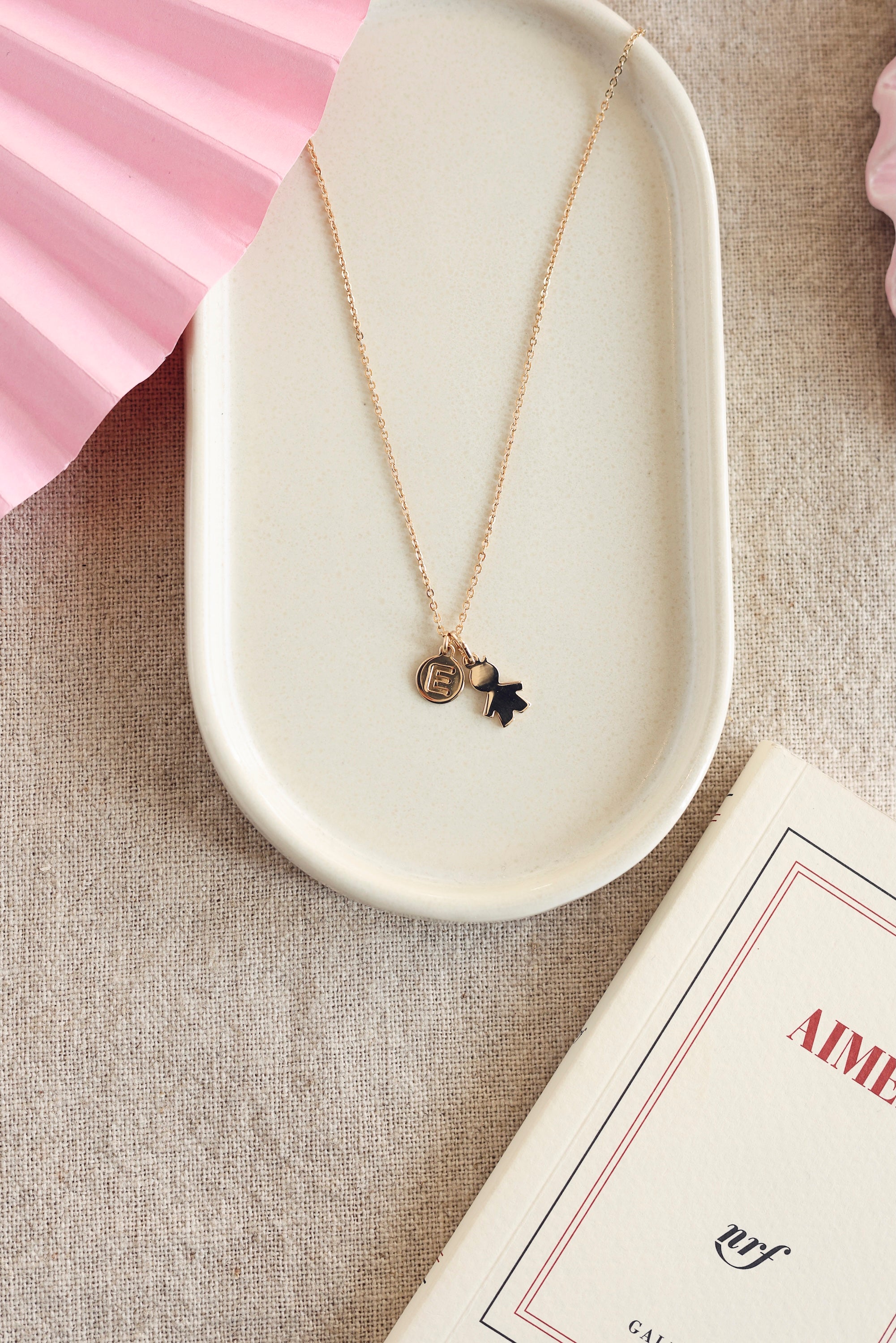 Pendentif doré petit garçon - Bijou photographié dans une coupole blanche