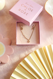 Coffret de parure de bijoux Heaven contenant un collier et une paire de créoles, ornés de pendentifs en forme de coeur - Bijoux photographiés dans leur écrin