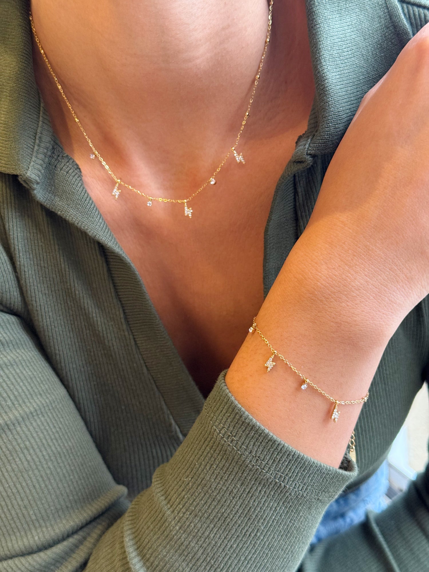 Coffret de parure de bijoux Davia éclair contenant un collier et un bracelet dorés, ornés de petits charms en forme d’éclair sertis de zircons - Bijoux portés