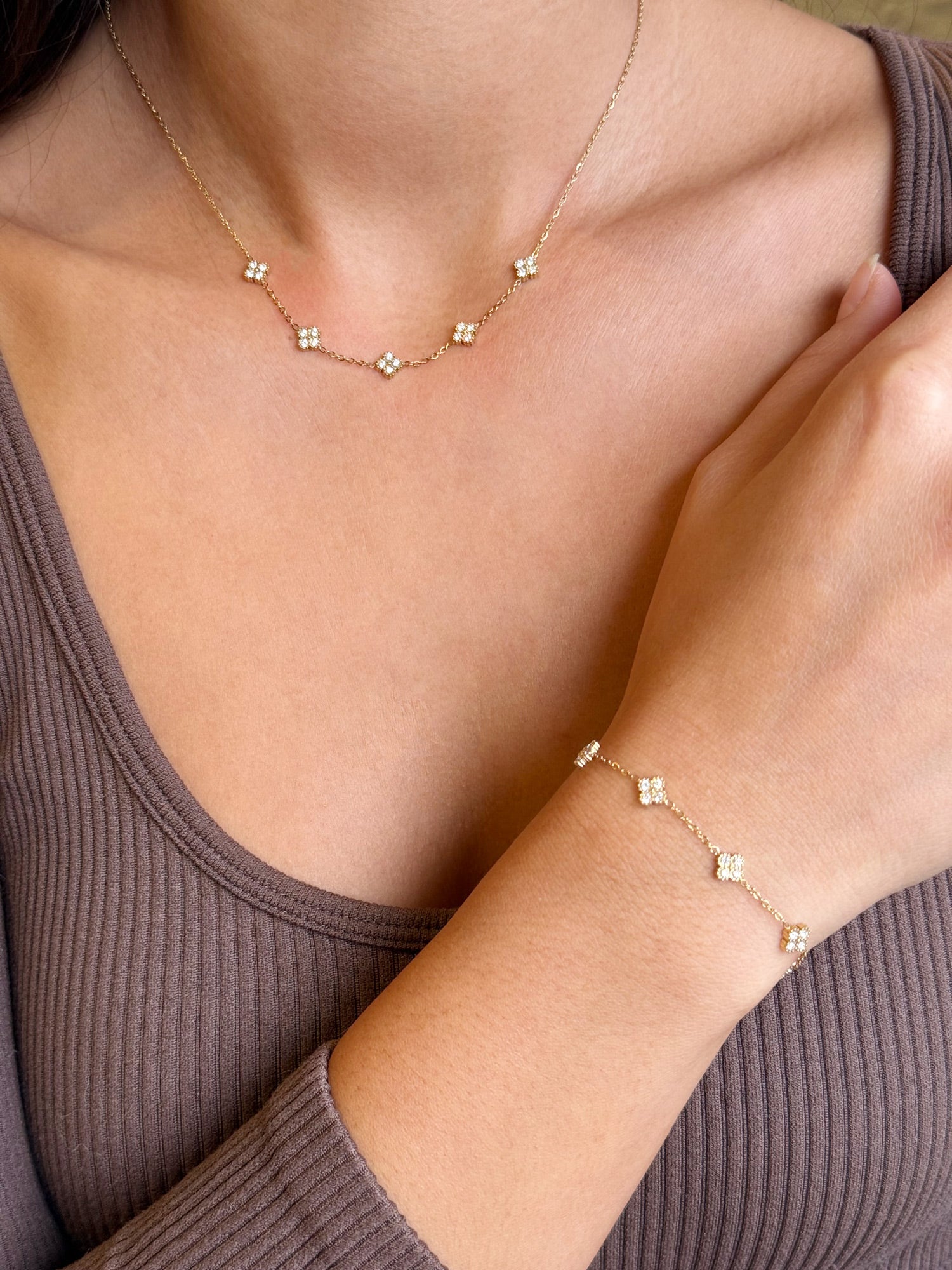 Coffret de parure Dolce comprenant une paire de mini créoles, un collier et un bracelet dorés, ornés de petites fleurs serties de zircons - Bijoux portés