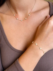 Coffret de parure Dolce comprenant une paire de mini créoles, un collier et un bracelet dorés, ornés de petites fleurs serties de zircons - Bijoux portés