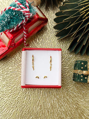 Coffret de parure de bijoux Tender contenant une paire de mini créoles et une paire de puces dorées - Bijoux photographiés dans un écrin à bijou rouge dans une ambiance de Noël