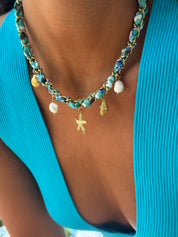 Collier doré Aminata maille entrelacée avec tissu turquoise pendentifs coquillages, étoile de mer et nacres - Bijou porté