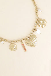 Collier maille doré Luz pendentifs soleil, cœur, trèfle, nacre et amulette avec inscription "amour" - Bijou photographié sur fond beige
