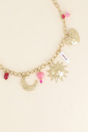 Collier maille doré Solal pendentifs soleil, cœur, Lune, pierres naturelles et amulette en nacre avec inscription "amour" - Bijou photographié sur fond beige