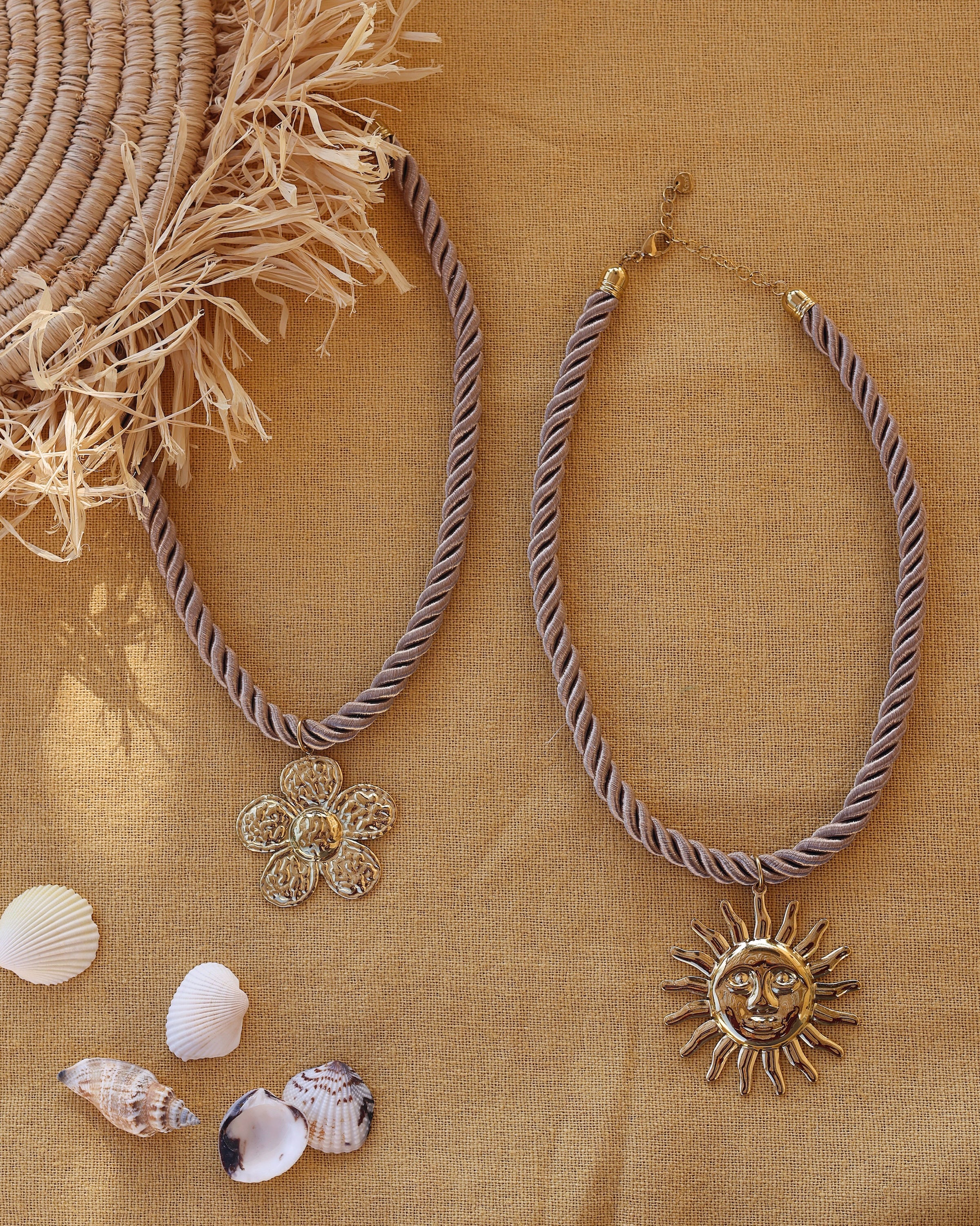 Collier doré Thao soleil gros cordon torsadé - Bijou photographié sur tissu jaune avec coquillages et paille