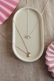 Collier personnalisable en argent Ama pendentifs étoiles pour lettre ou charm - Bijou photographié dans un vide poche blanc