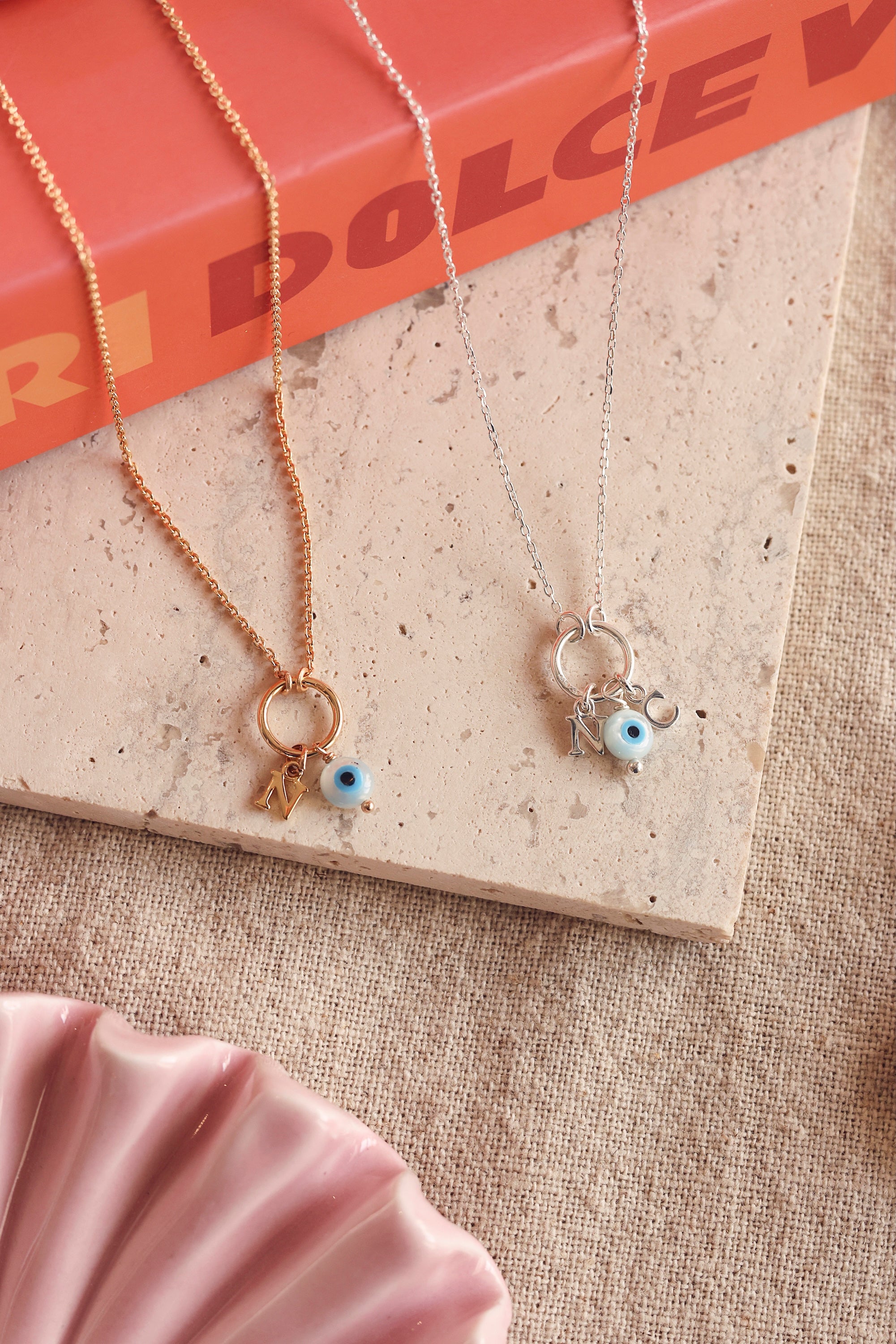 Collier personnalisable en argent Lilou protect avec anneau et pendentif œil protecteur en nacre pour lettres de l'alphabet et charms - Bijou photographié sur une pierre