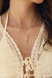 Collier doré Iranya orné d'un pendentif serti de zircons blancs et bleus - Bijou porté
