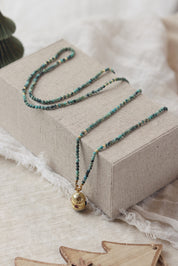 Collier sautoir doré pierres naturelles et pendentif talisman Joe turquoise africaine - Bijou photographié dans un décor de Noël