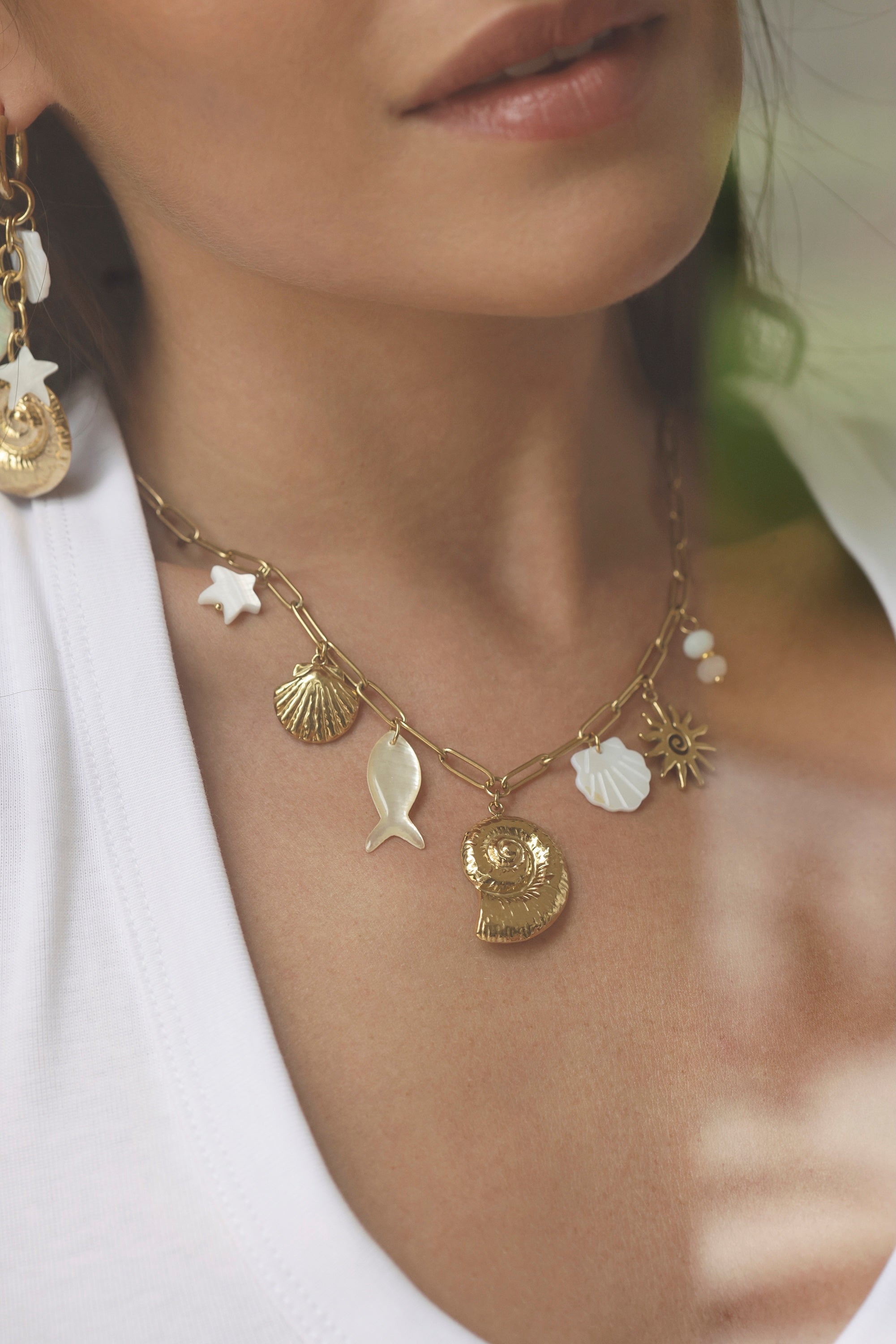 Collier doré Nelly chaîne en maille avec pendentifs coquillages, étoile de mer, poisson et soleil - Bijou porté