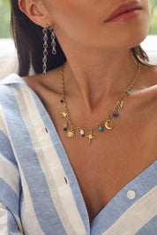 Collier doré Orlina chaîne en maille avec pendentifs étoiles, cœur, lune, soleil, étoile polaire et pierres naturelles - Bijou porté