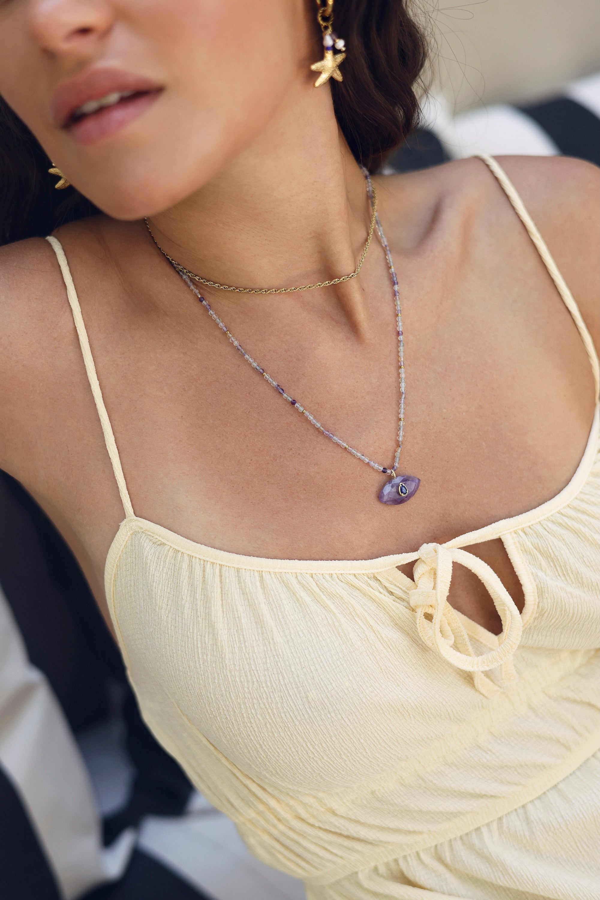 Collier sur fil doré Thelma améthyste composé de perles en améthyste avec pendentif en forme d'œil orné d'une goutte en lapis lazuli - Bijou porté
