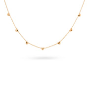 Collier doré orné de cœurs - Bijou sur fond banc