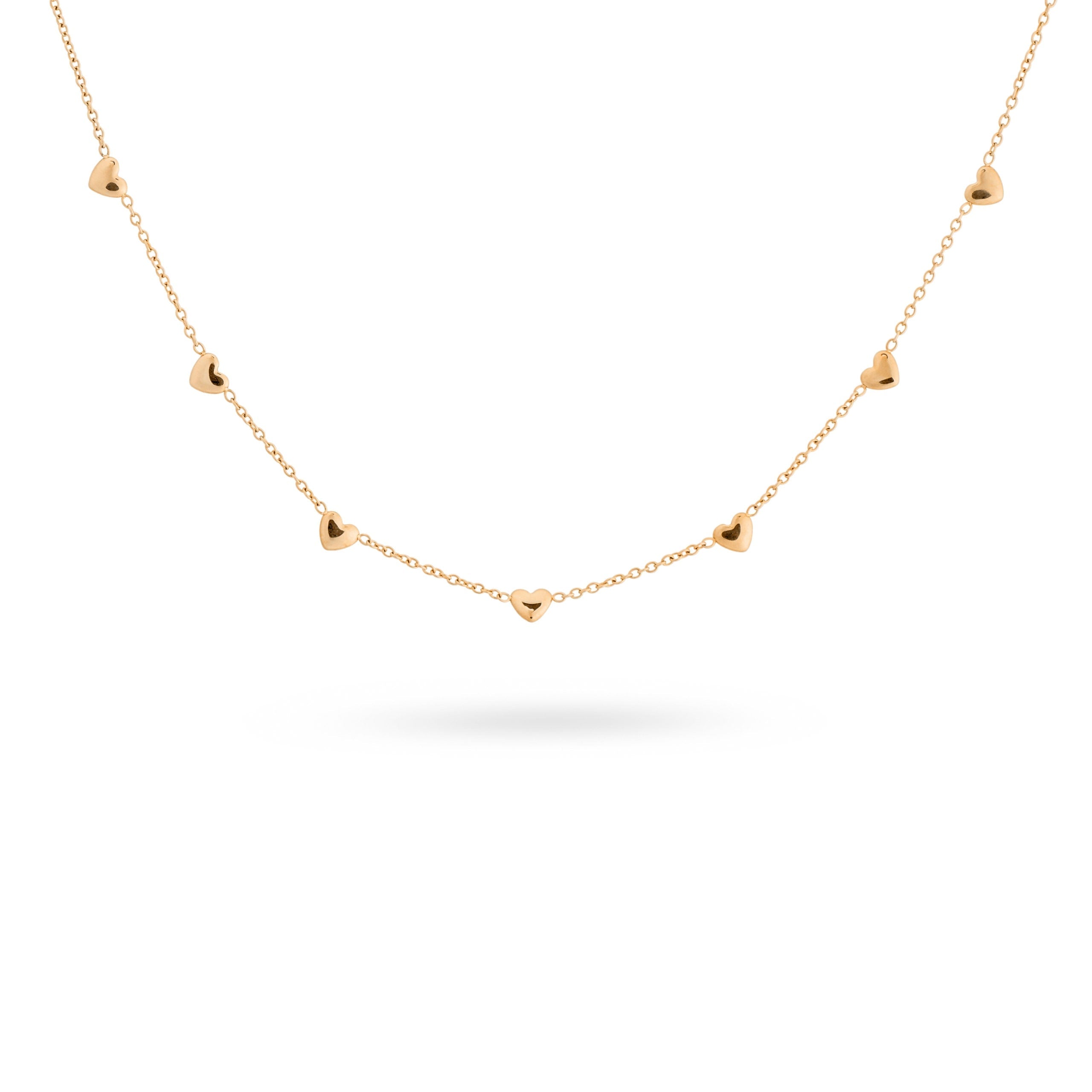 Collier doré orné de cœurs - Bijou sur fond banc
