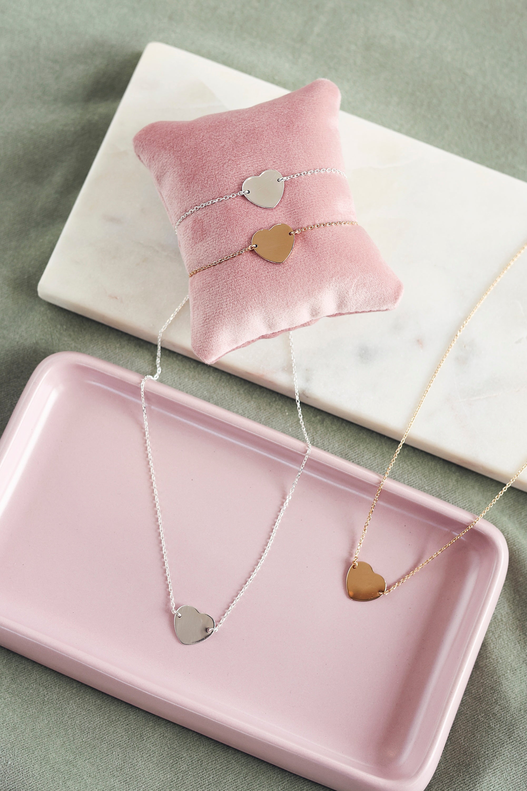 Collier personnalisable doré Adelie chaîne fine et médaille en forme de cœur à graver - Bijou photographié dans une coupole rose 