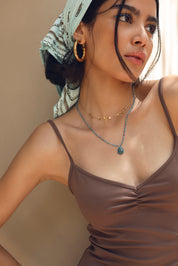 Collier Anthea sur fil doré composé de perles en apatite avec pendentif en forme de goutte orné d'un zircon bleu - Bijou porté