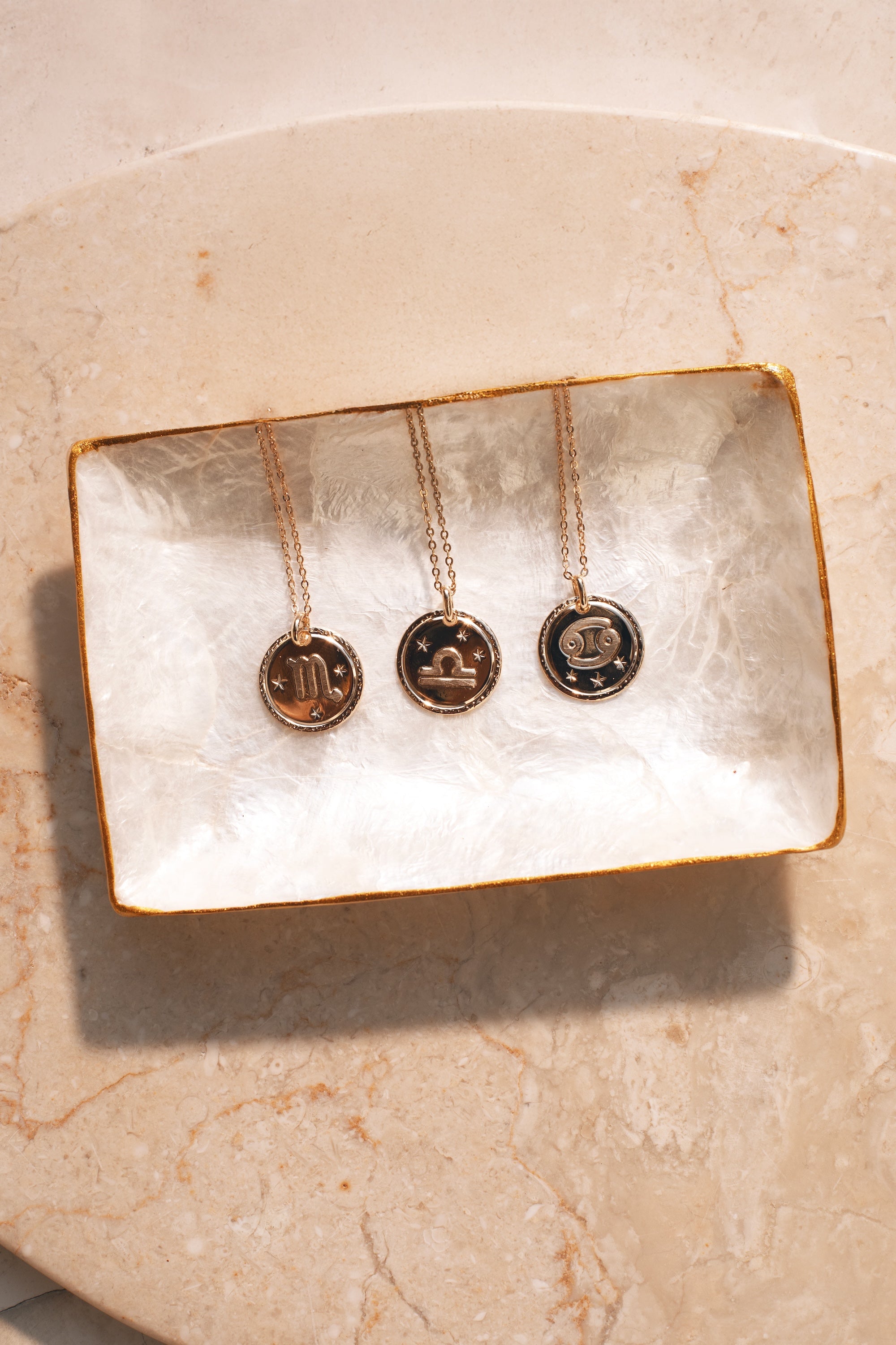  Collier doré signe du zodiaque Balance - Bijou photographié dans coupole en nacre