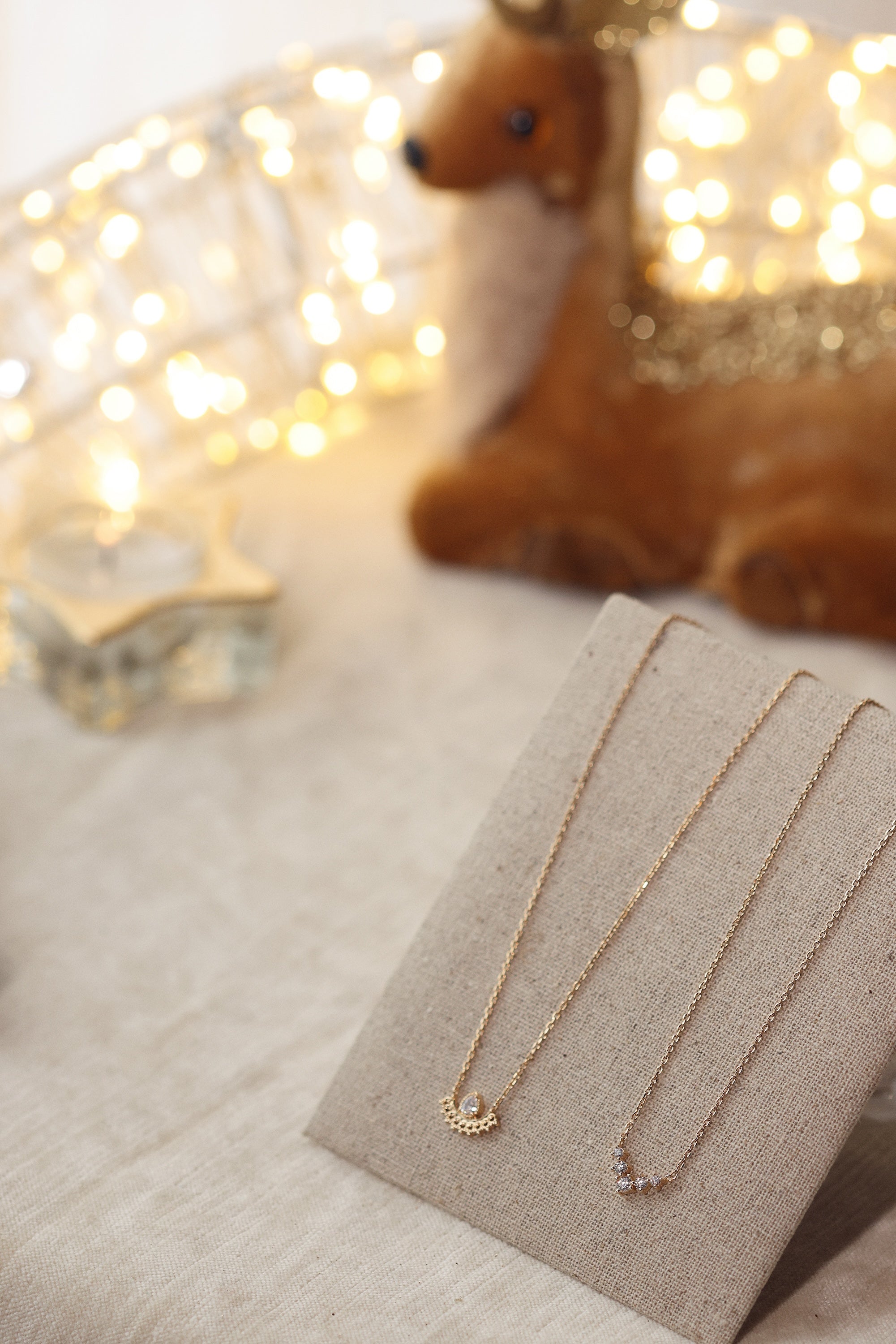 Collier doré Béna - Bijou photographié sur présentoir en lin