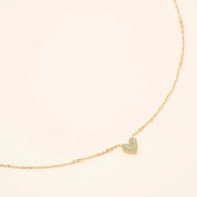 Collier Petit Coeur pour enfant doré pendentif coeur vert - Bijou photographié sur fond beige
