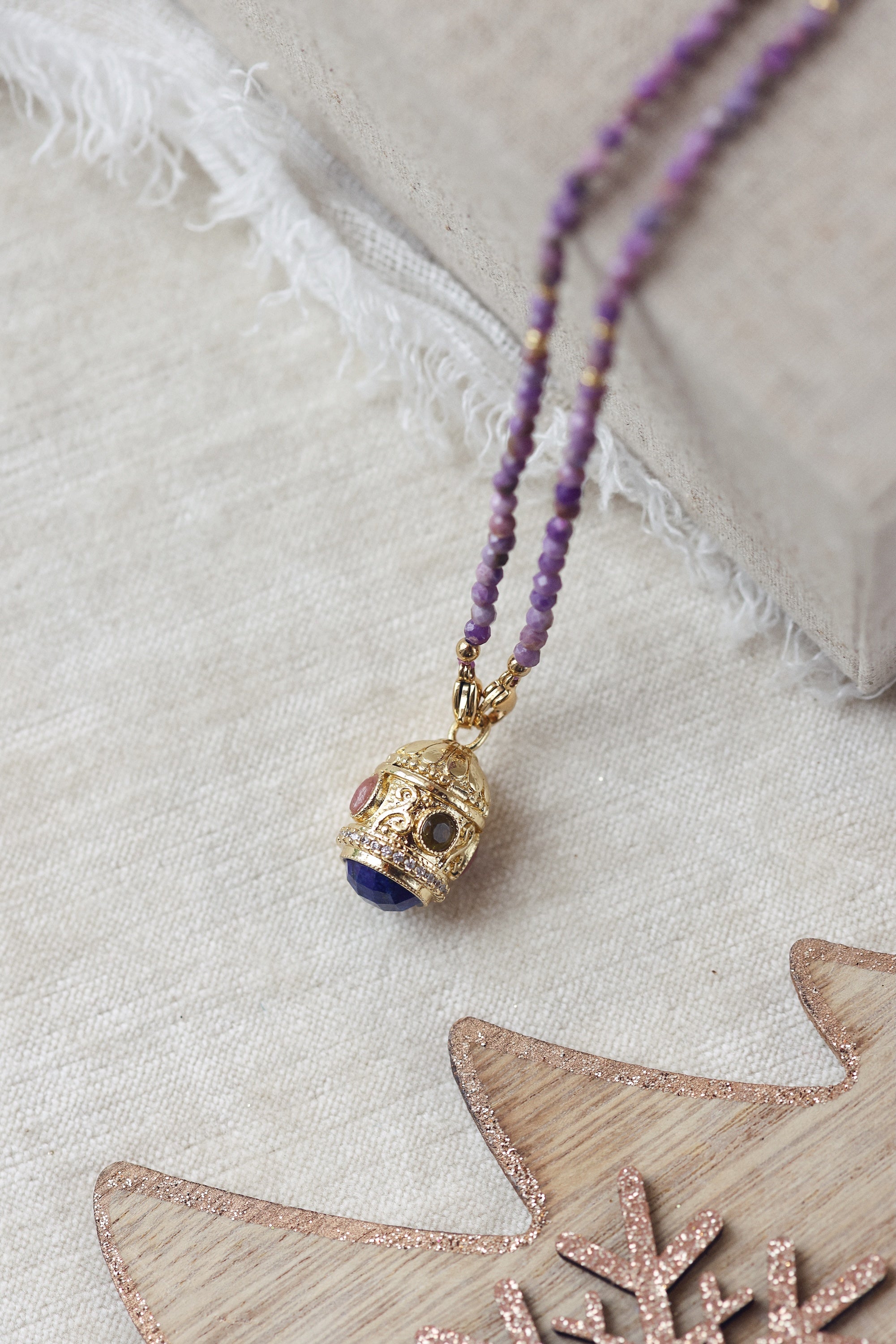 Collier sautoir doré pierres naturelles et pendentif talisman Joe agate mauve - Bijou photographié dans un décor de Noël