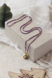 Collier sautoir doré pierres naturelles et pendentif talisman Joe agate mauve - Bijou photographié dans un décor de Noël
