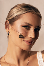 Collier Mantra coeur laiton doré 3 microns imaginé et créé par Chloé Rose - Bijou porté dans les mains côté gravure