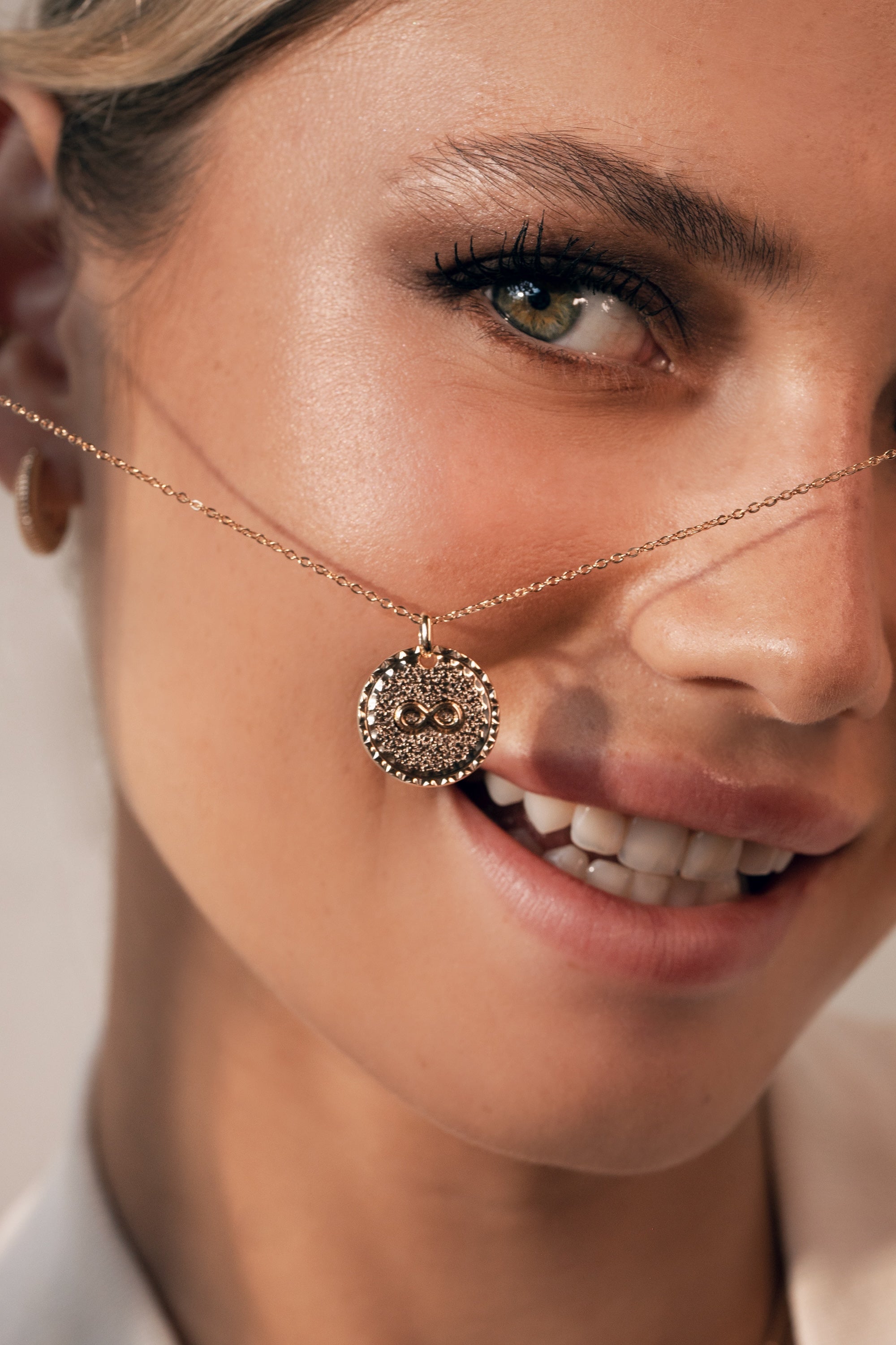 Collier Mantra infini laiton doré 3 microns imaginé et créé par Chloé Rose - Bijou porté dans les mains