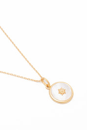 Collier doré médaillon soleil et nacre - Bijou photographié sur fond blanc