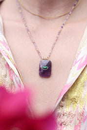 Collier sur fil doré composé de perles en améthyste avec pendentif rectangulaire orné d'un œil en malachite - Bijou porté