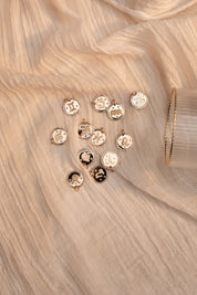 Collier doré signe du zodiaque Cancer - Bijou photographié sur tissu beige 