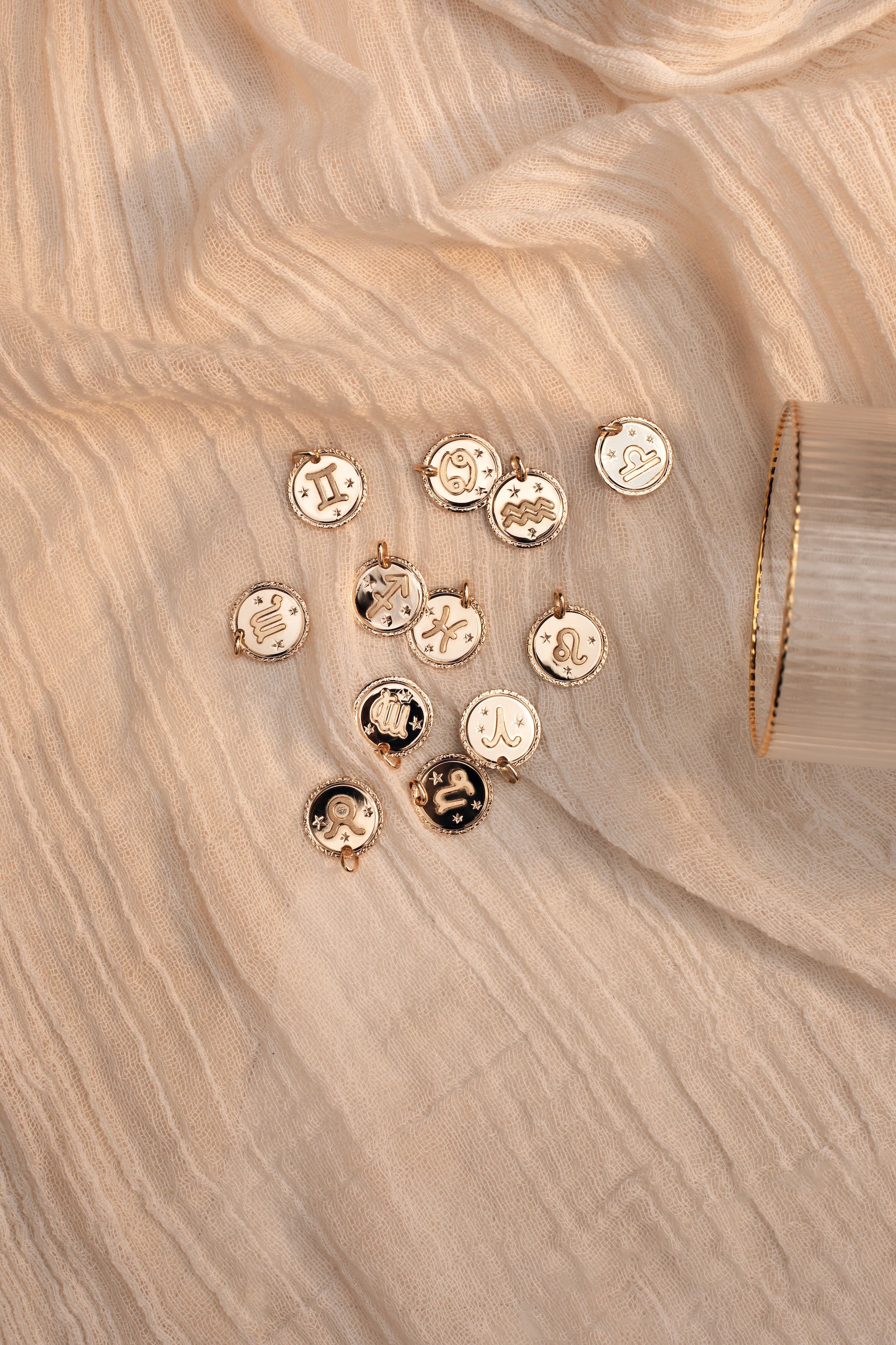 Collier doré signe du zodiaque Verseau - Bijou photographié sur tissu blanc crème