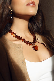 Collier statement doré Ginie brun en acétate avec un pendentif cœur - Bijou porté