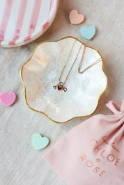 Collier doré Lilou passion personnalisable avec pendentif cœur rouge - Bijou photographié dans une coupole en nacre dans une ambiance saint valentin