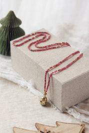 Collier sautoir doré Joe agate rose pierres naturelles et pendentif talisman - Bijou photographié dans un décor de Noël
