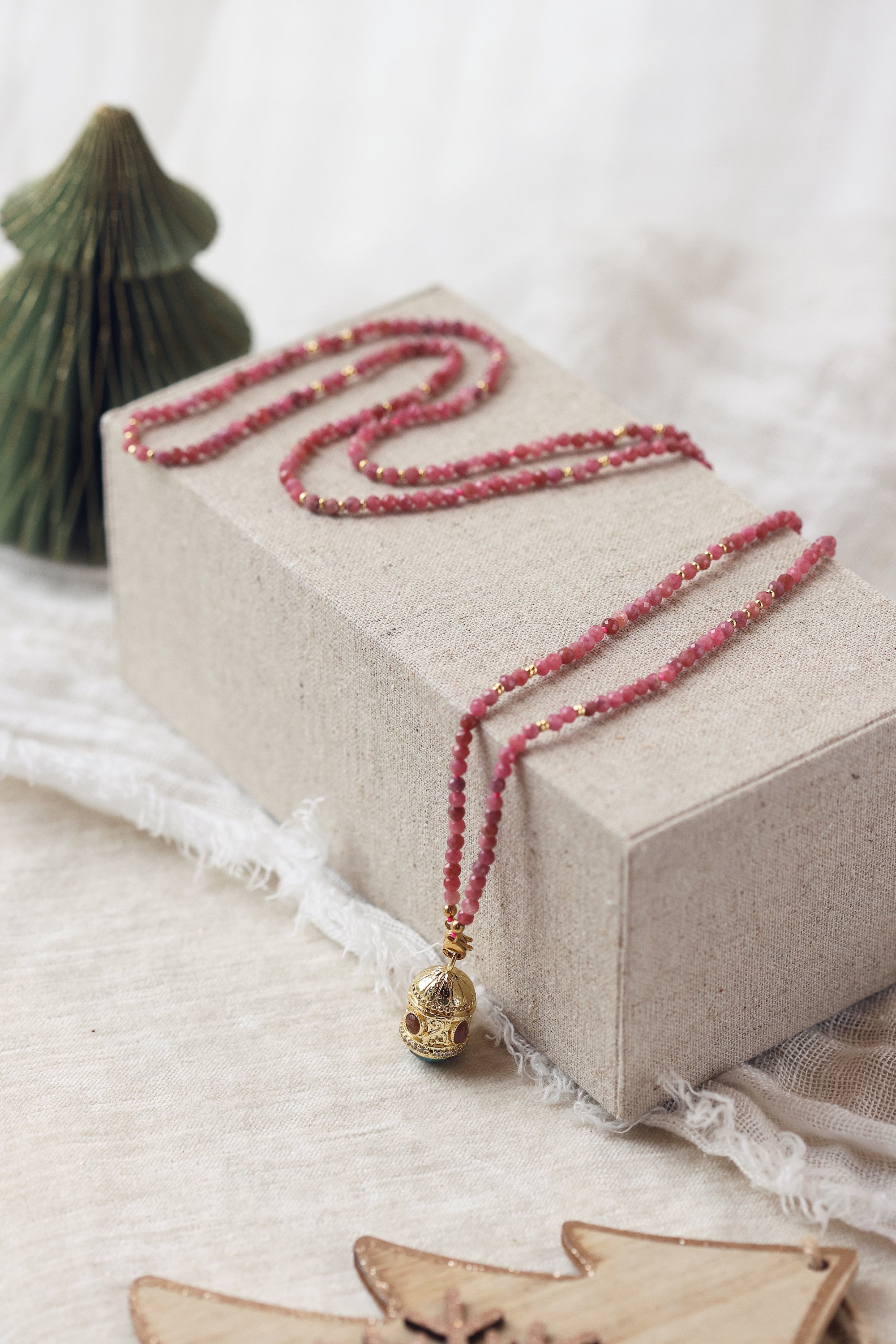 Collier sautoir doré Joe agate rose pierres naturelles et pendentif talisman - Bijou photographié dans un décor de Noël
