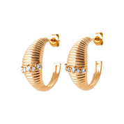 Boucles d'oreilles créoles dorées Ethani striées ornées de zircons - Bijou photographié sur fond blanc
