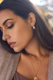 Boucles d'oreilles créoles dorées Ethani striées ornées de zircons - Bijou porté