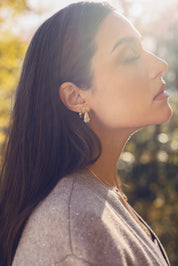 Boucles d'oreilles créoles dorées Ethani striées ornées de zircons - Bijou porté