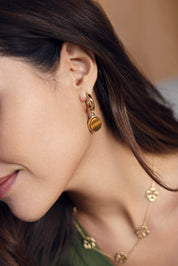 Boucles d'oreilles mini créoles dorées Mabelle oeil de tigre avec pendentif rond orné d'une pierre naturelle - Bijou porté
